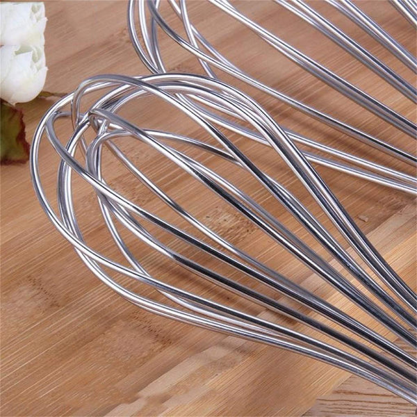 Metal whisk on a wooden surface