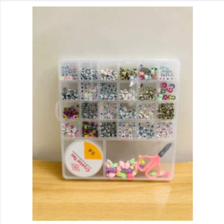 Clear plastic organizer with compartments filled with small items on a wooden surface.
