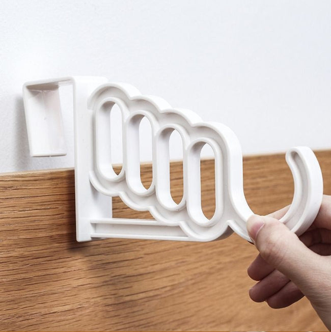 Pack of two white mini plastic over-the-door hook hangers, each showing 4 small holes and 1 large hook, hanging towels and a robe on a bathroom door.