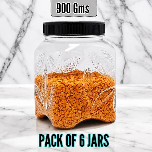 Clear PLASTIC jar with orange contents and black lid on a marble background, labeled '900 Gms' and 'Pack of 6 Jars'.