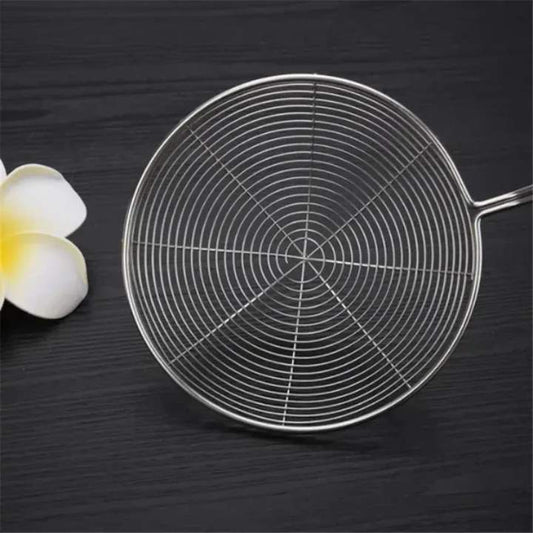 Metal strainer on a dark surface with a flower beside it