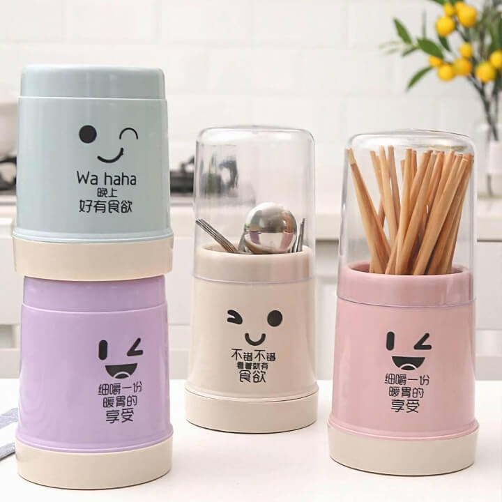 Three colorful containers with cartoon faces and text on a white surface.