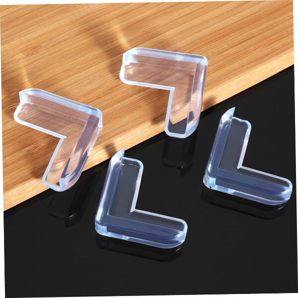 Clear L-shaped corner protectors on a wooden and black surface