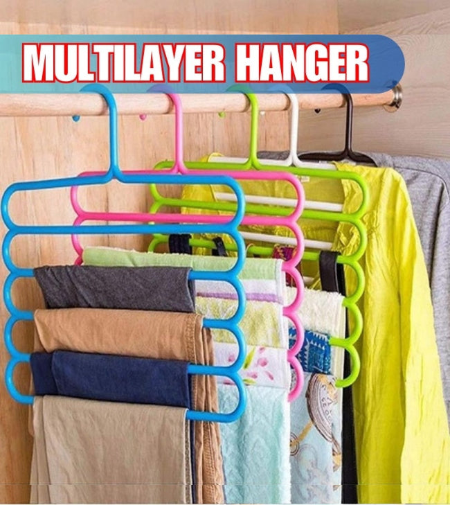 Multi-layer space-saving clothes hanger loaded with five pairs of pants hanging vertically in a closet, demonstrating the 5-in-1 storage capacity.