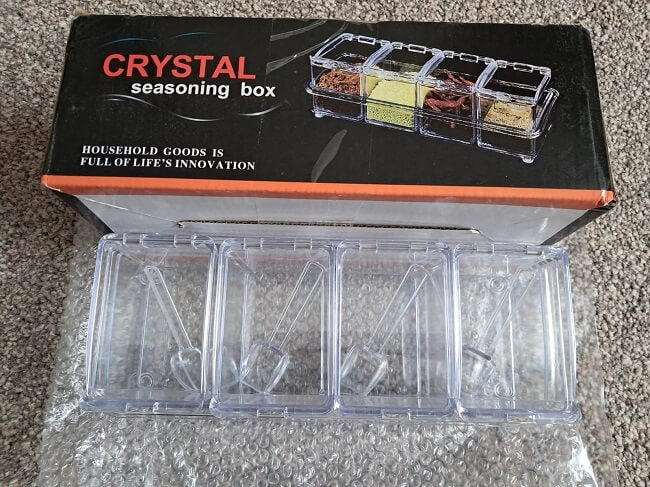 Crystal seasoning box with compartments on a gray surface