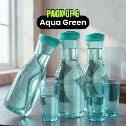 A set of six aqua green glass water containers, including three carafes and three glasses, arranged on a table in front of a softly blurred indoor background. A black text overlay at the top reads 'PACK OF 6 Aqua Green'.