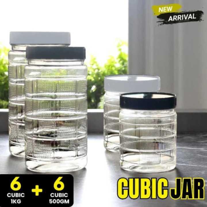 Set of clear cubic jars with black lids on a surface with a blurred outdoor background.