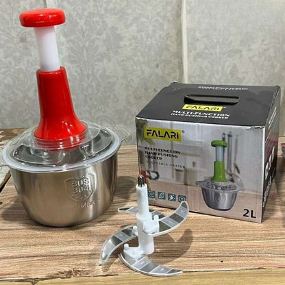 Multifunctional food processor with red top and metal base, next to its packaging box on a wooden surface.