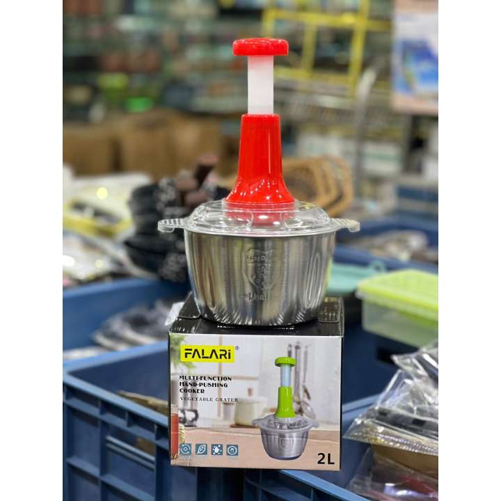 Metallic juicer with red top on a display stand in a store setting