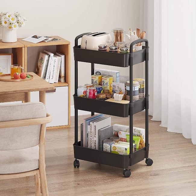 White 3-tier plastic rolling utility cart with handle, featuring 360-degree rotating wheels, holding vegetables and kitchen essentials.