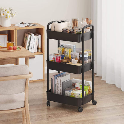 White 3-tier plastic rolling utility cart with handle, featuring 360-degree rotating wheels, holding vegetables and kitchen essentials.