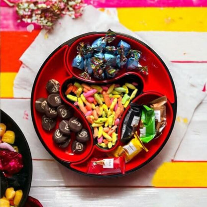 Assorted candies in a red tray on a colorful striped background