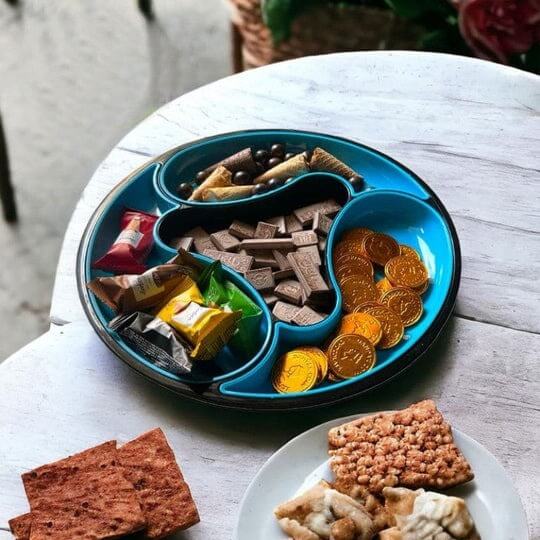 Blue divided plate with snacks on a white table