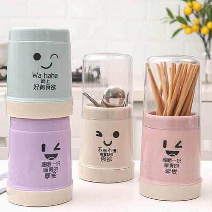 Three colorful containers with cartoon faces and utensils on a white background