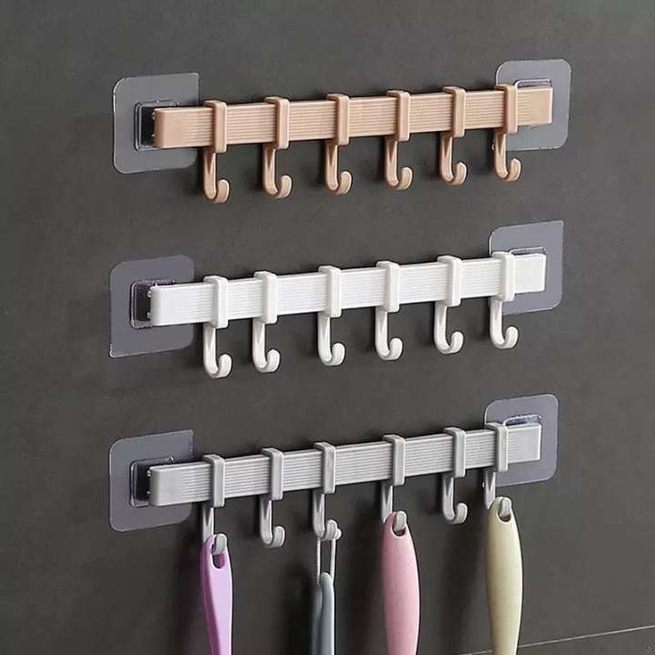 Set of wall hooks in beige, white, and gray on a dark wall.