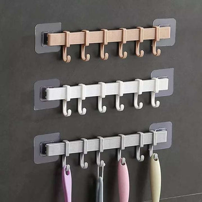 Set of wall hooks in beige, white, and gray on a dark wall.