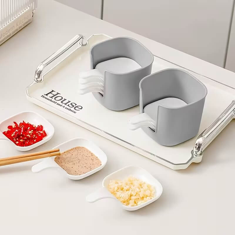Gray kitchen utensil holder with cutlery on a white surface