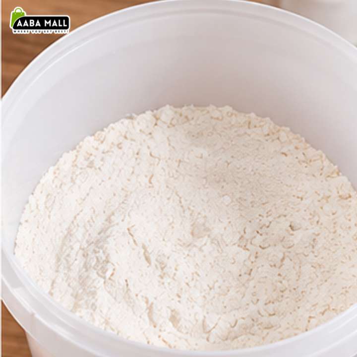 A close-up of white flour piled inside a large white plastic tub, with a small AABA MALL logo in the top-left corner.