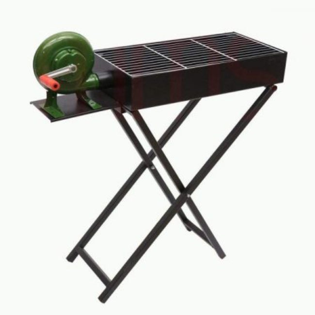 A black portable charcoal BBQ grill with a stand, showing the side-mounted manual hand-crank blower fan integrated into the unit.