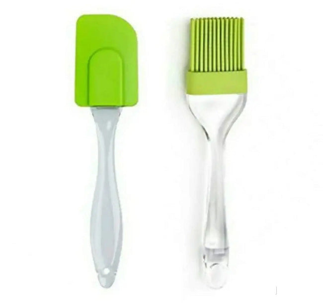 Set of 2 mini silicone kitchen tools (spatula and pastry brush) in blue, shown scraping the remnants of cake batter out of a small mixing bowl, illustrating the compact size.
