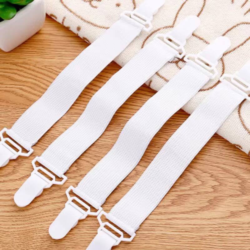 White elastic straps with clips on a wooden surface