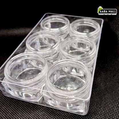 Six small clear plastic round jars arranged in a transparent plastic tray on a dark textured surface. An AABA MALL logo watermark is visible in the top right corner.