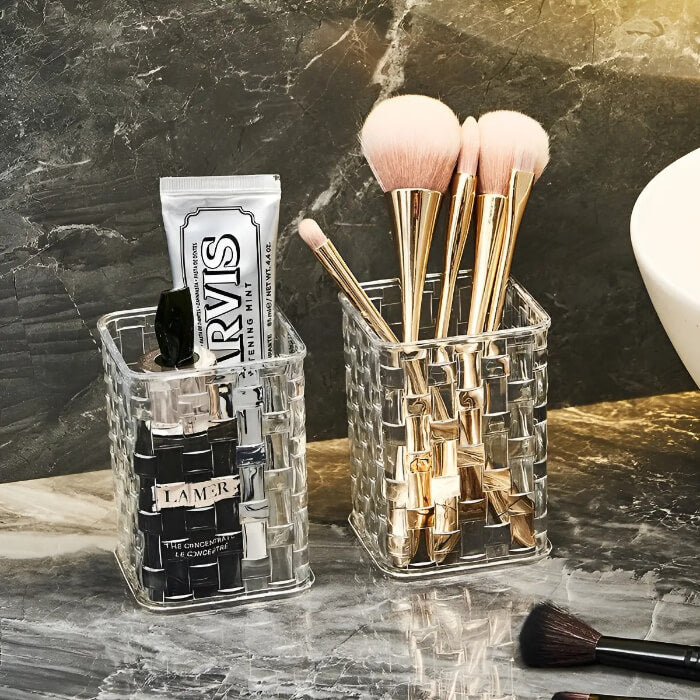Clear acrylic makeup organizer with brushes and skincare products on a marble surface