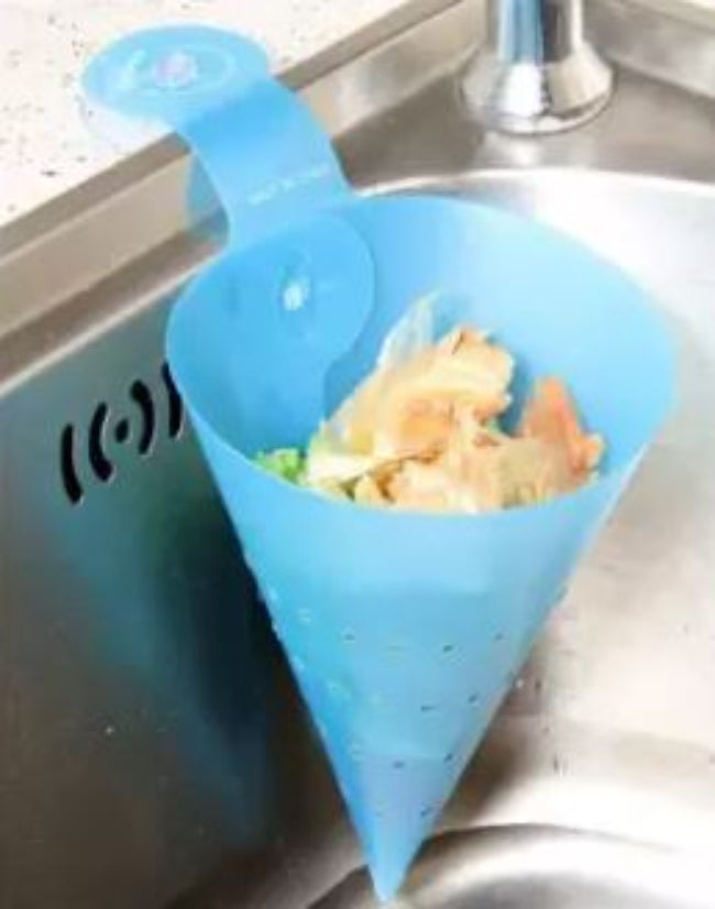 Foldable plastic triangle kitchen sink strainer basket, shown attached to the corner of a kitchen sink, draining water from freshly washed vegetables.