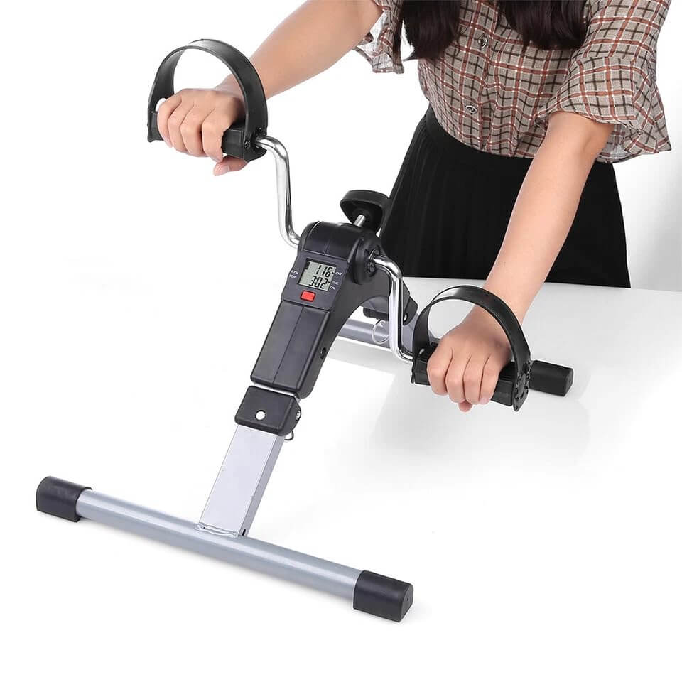 Person using a mini exercise bike on a white background