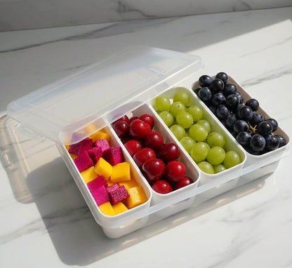 Fruit salad in a compartmentalized container on a marble surface