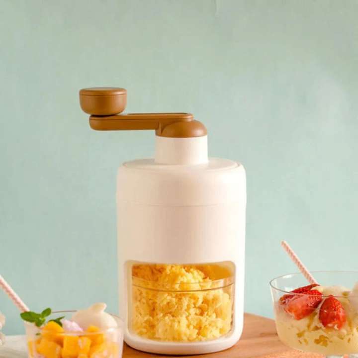 White and brown kitchen appliance on a light blue background with a glass of fruit salad.