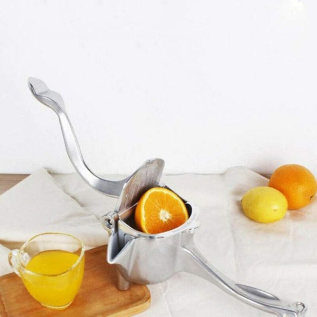 Heavy-duty stainless steel manual hand squeeze juicer press, shown extracting fresh orange juice into a glass, highlighting the stable base and lever mechanism.