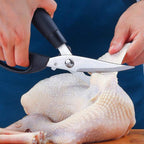 Person using kitchen shears to cut a chicken on a blue background