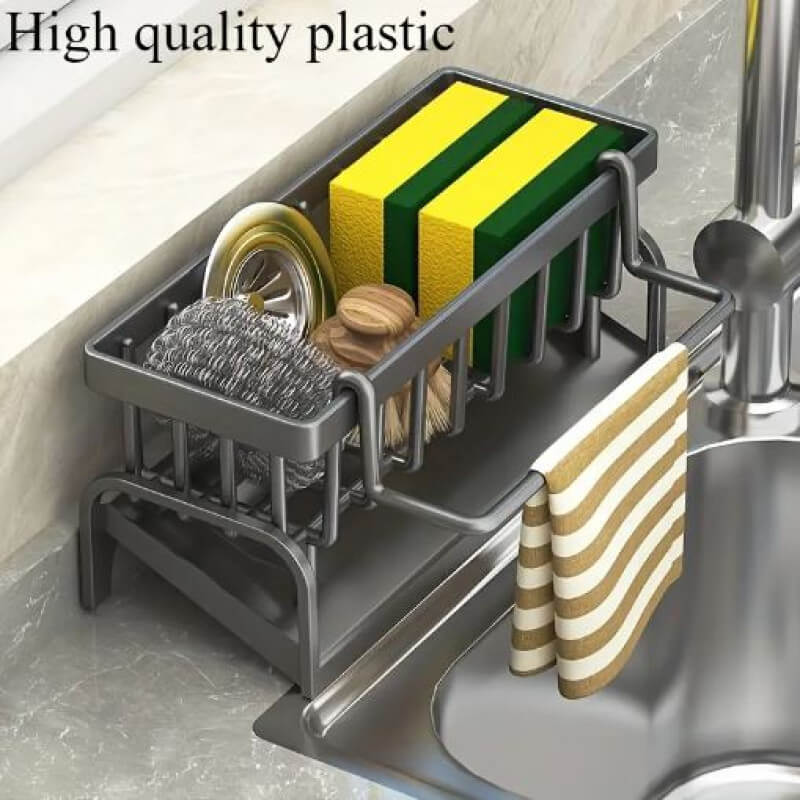 Kitchen sink caddy with sponges, scrubber, and towel on a kitchen counter.