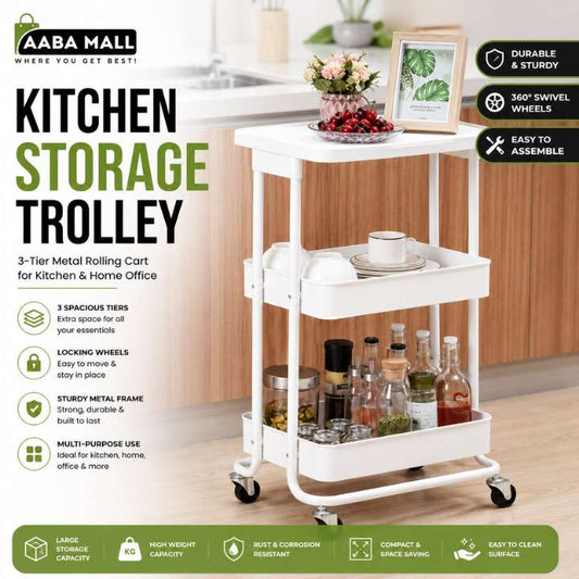 A white 3-tier metal rolling cart labeled as a kitchen storage trolley, shown in a kitchen setting with bottles, jars, and decorative items on its shelves. The image includes marketing text and feature icons on a green and white layout.