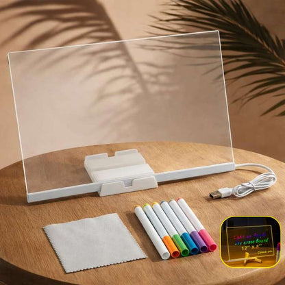 Clear electronic display board with markers and cleaning cloth on a wooden surface