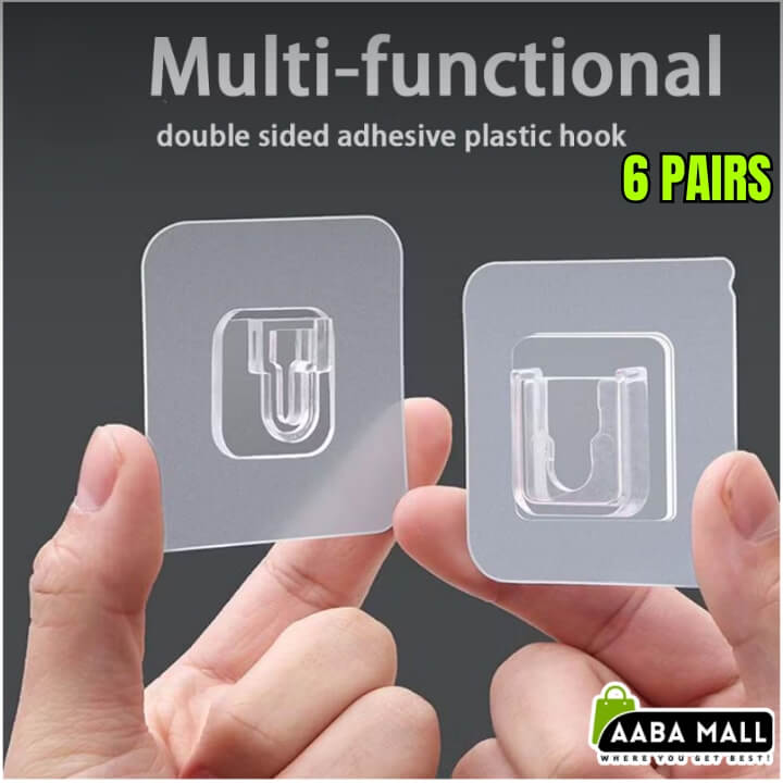 Two clear double-sided adhesive plastic hooks held by hands with a dark background and 'AABA MALL' branding.