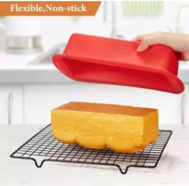 Flexible non-stick silicone loaf pan in red, shown holding a baked banana bread loaf that is easily being removed from the mold, illustrating the easy release.