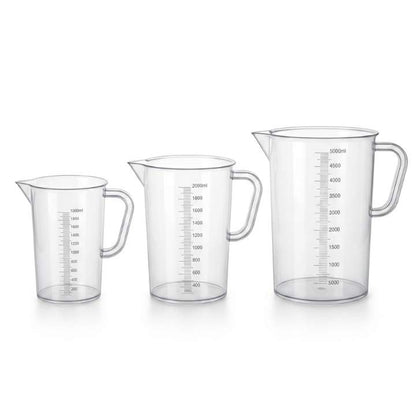 Set of three clear measuring jugs with measurement markings on a white background