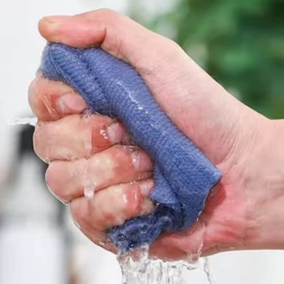 Hand using a blue sponge to scrub another hand under running water