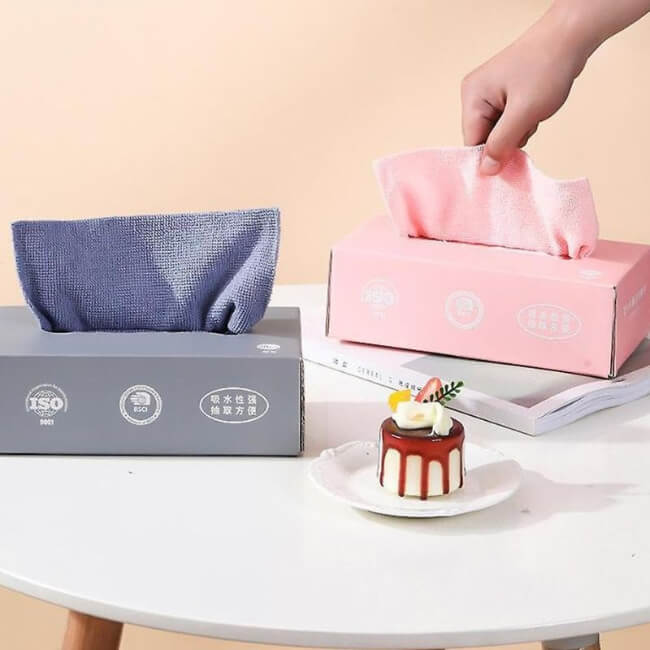 Tissue boxes on a table with a dessert and a hand reaching for a tissue.