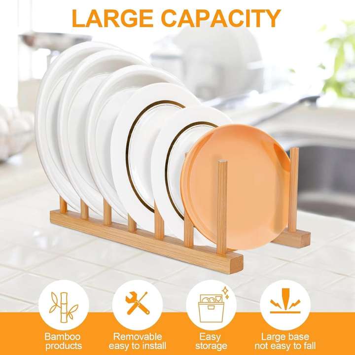 A bamboo plate drying rack holding several white plates with gold rims and one orange plate, shown in a bright kitchen setting. Orange text at the top reads 'LARGE CAPACITY,' and four feature icons at the bottom mention bamboo construction, easy removal/installation, easy storage, and a large base that is not easy to fall.