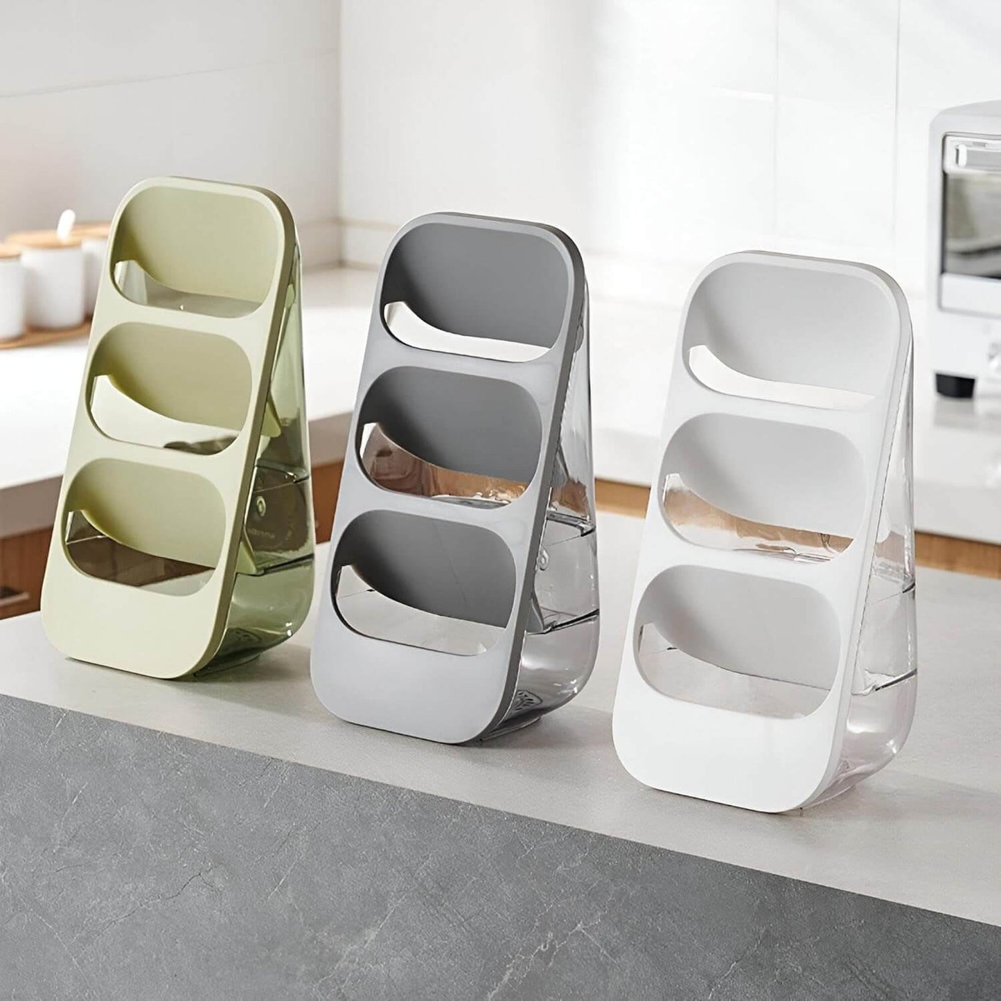 Three modern salt and pepper shakers in green, gray, and white on a kitchen counter.