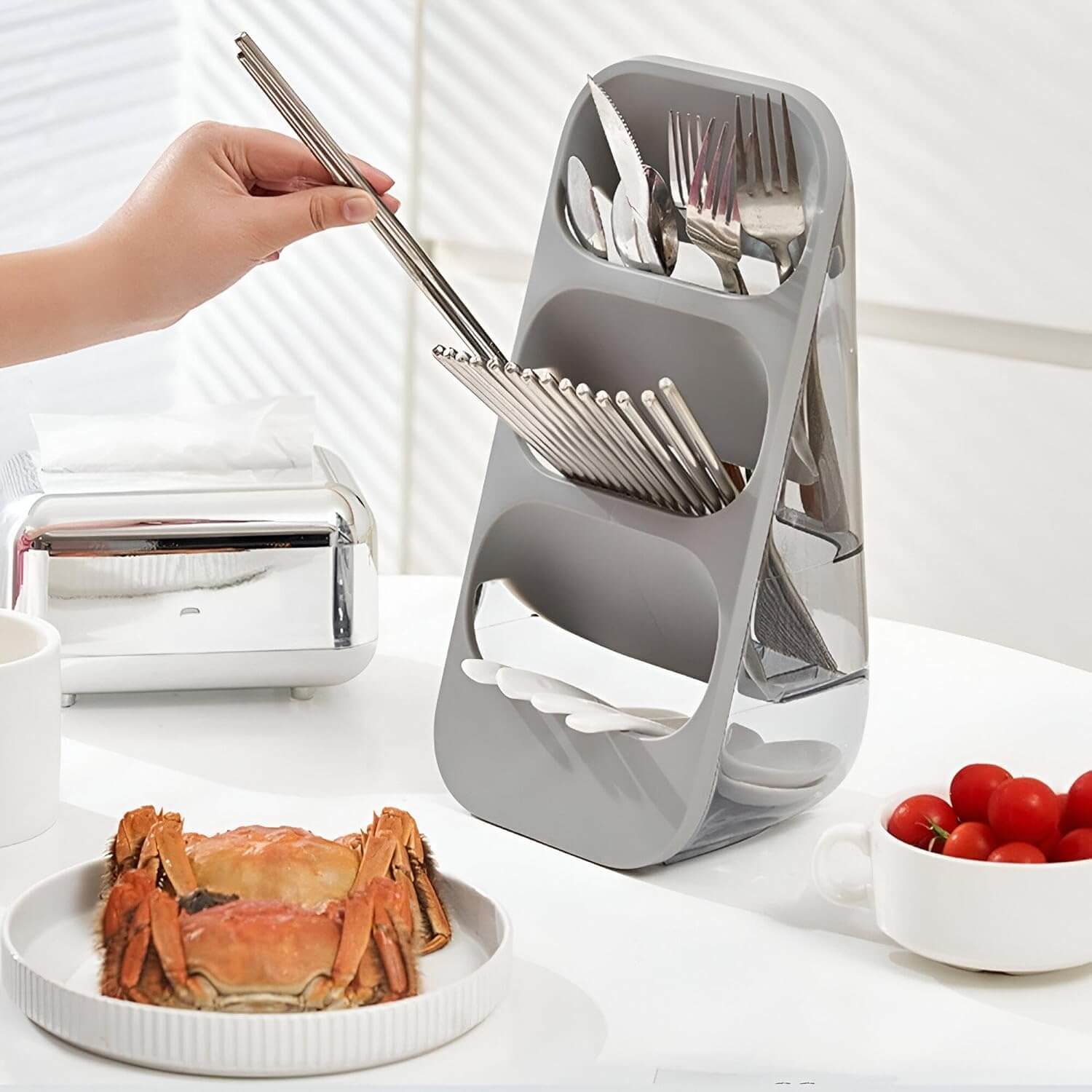 Gray kitchen utensil holder with cutlery on a table with food items.