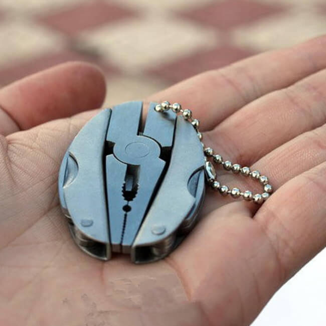 Multitool keychain held in a hand with a blurred background