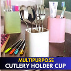 Multi-purpose plastic cutlery storage basket standing on a kitchen counter, holding spoons, forks, and knives in separate compartments, showing drainage holes.
