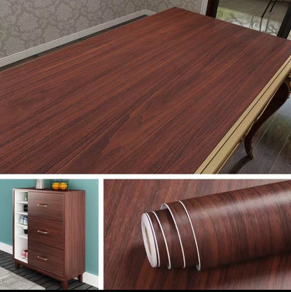 Roll of dark brown wood grain peel and stick wallpaper next to a kitchen countertop it has been applied to. Shows the waterproof, oil-proof, and self-adhesive features.