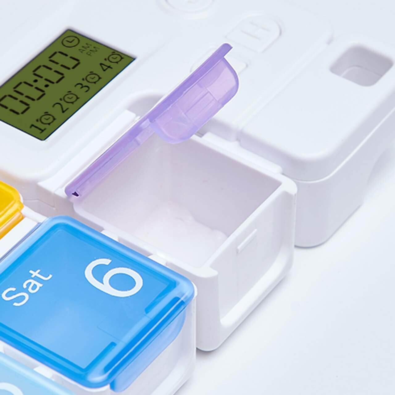 Multicolored pill organizer with digital display on a white background