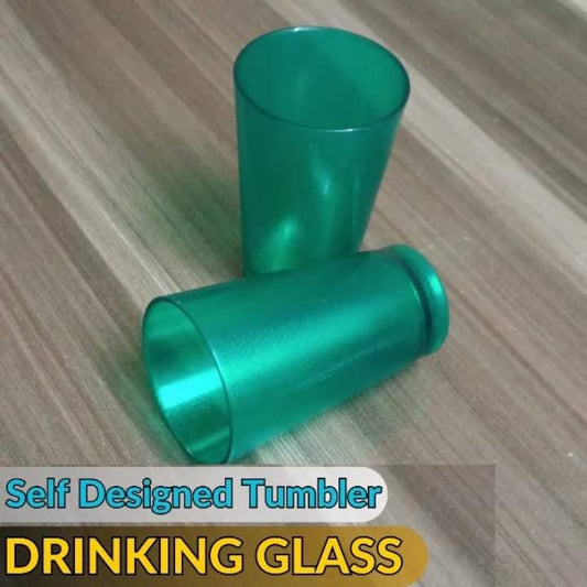 Two green tumblers on a wooden surface with text 'Self Designed Tumbler DRINKING GLASS'.
