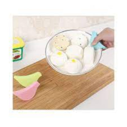 Close-up of a brightly colored silicone hot plate holder / trivet with a honeycomb pattern, shown supporting a steaming hot black iron skillet on a kitchen counter.